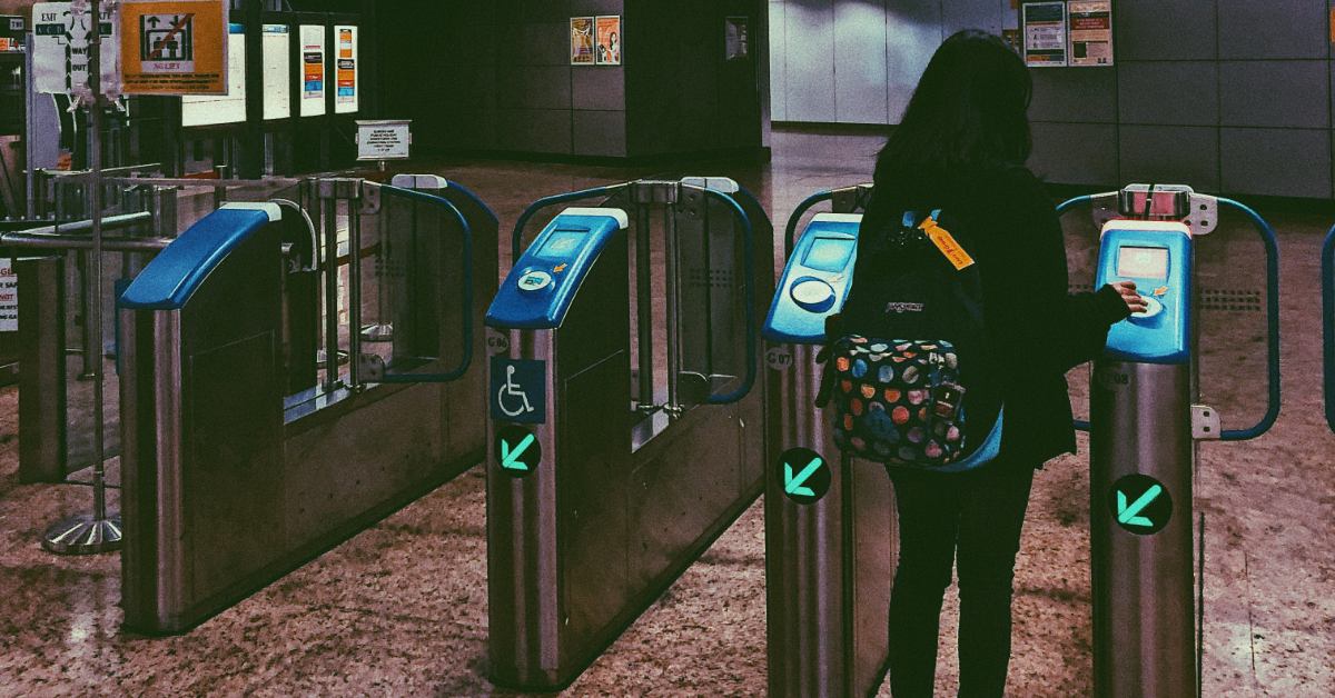 Woman going through self-service kiosks at a transportation center.