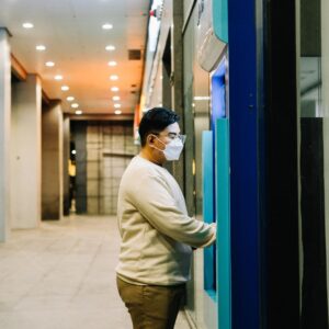 A person wearing a mask at a kiosk