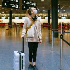 A woman in an airport wearing a face mask